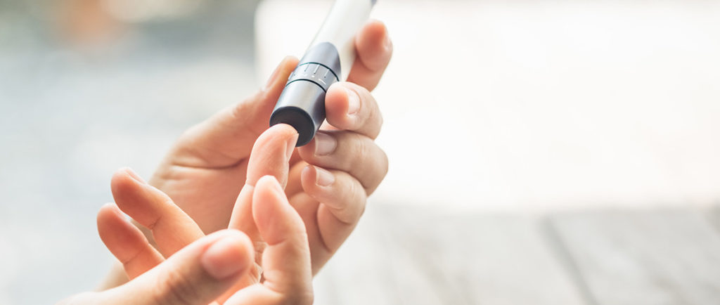 A person pricks their finger to test their blood sugar