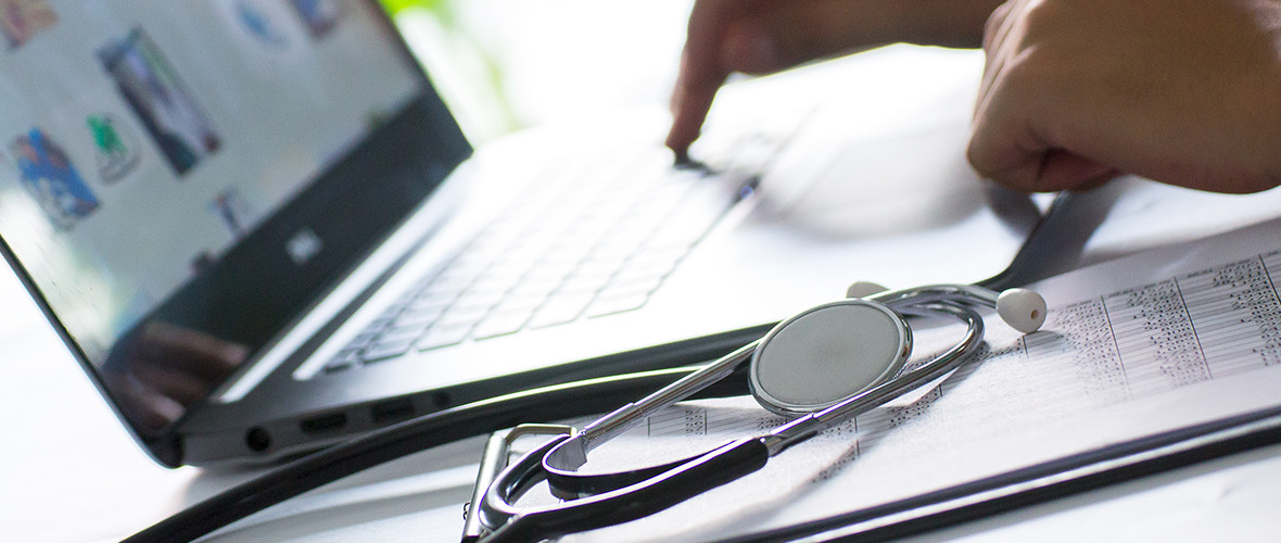 Doctor with stethoscope using a laptop