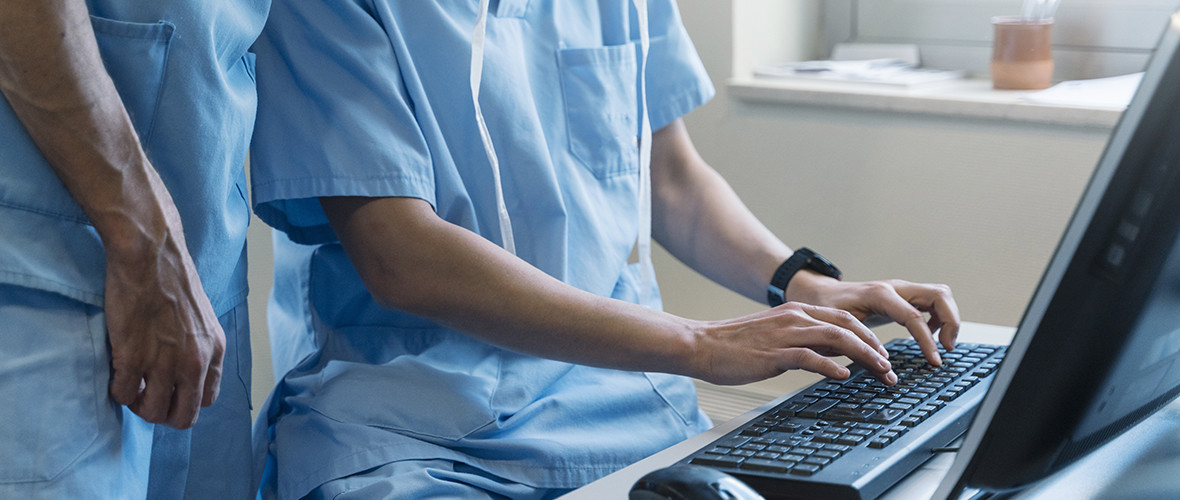 two doctors typing on a computer