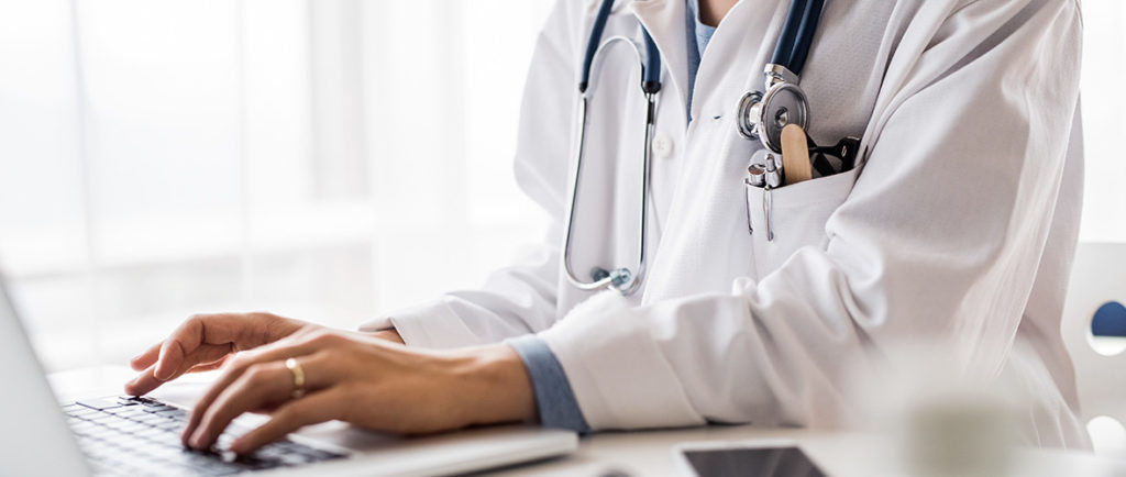 Doctor typing on a laptop