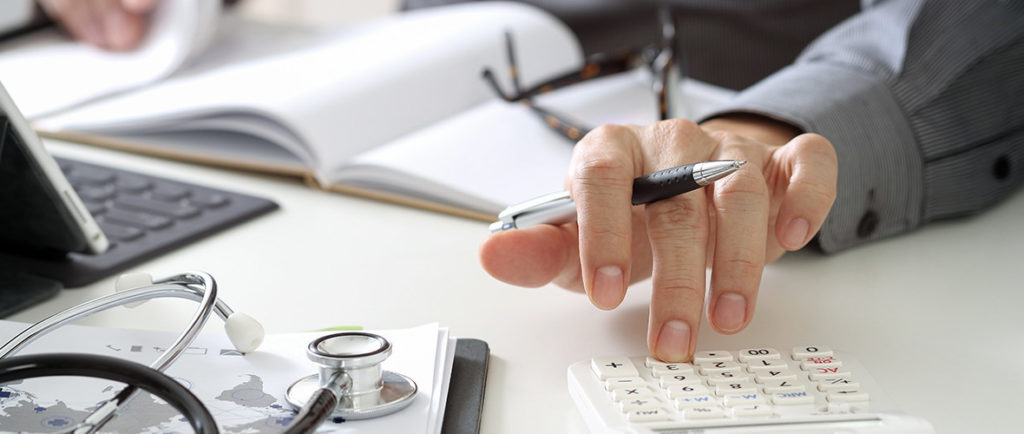 a person writing and using a calculator