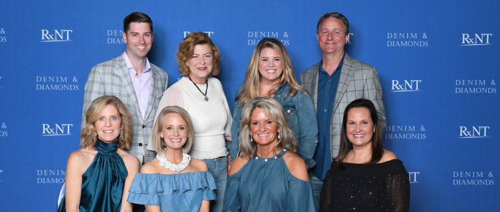 Members of the RXNT team in front of an event banner