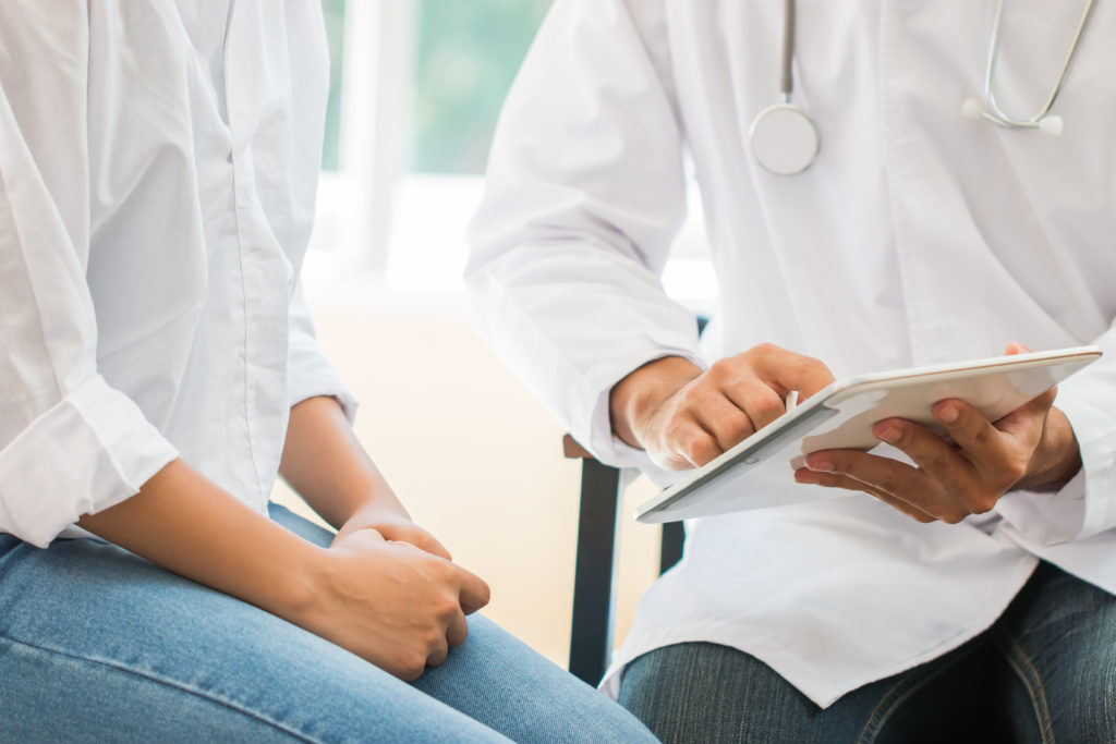 Doctor using tablet to show patient information