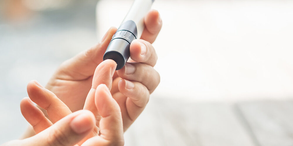 A person pricks their finger to test their blood sugar
