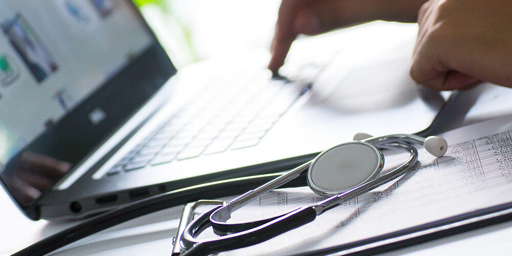 Doctor with stethoscope using a laptop