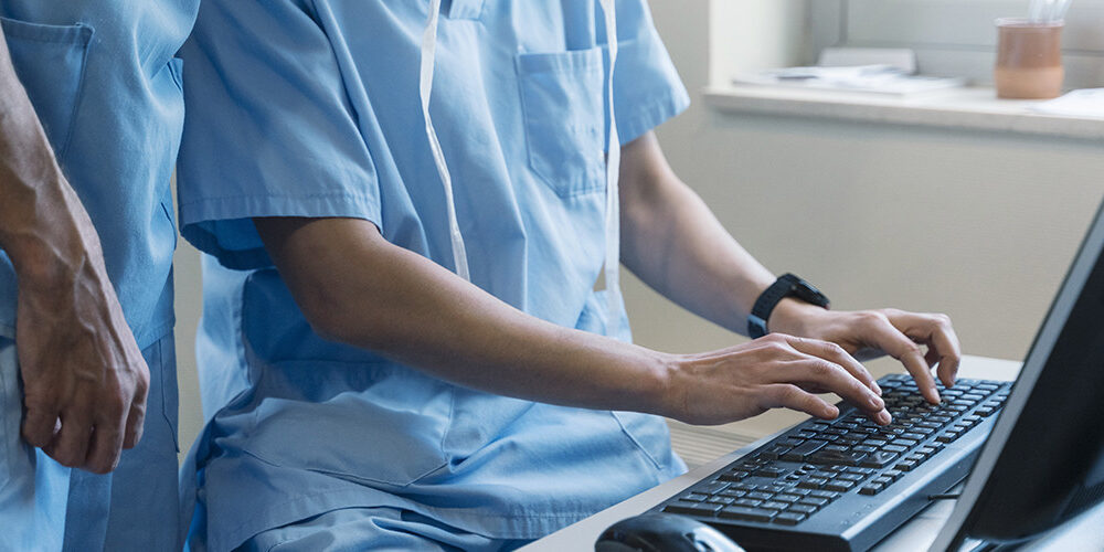 two doctors typing on a computer