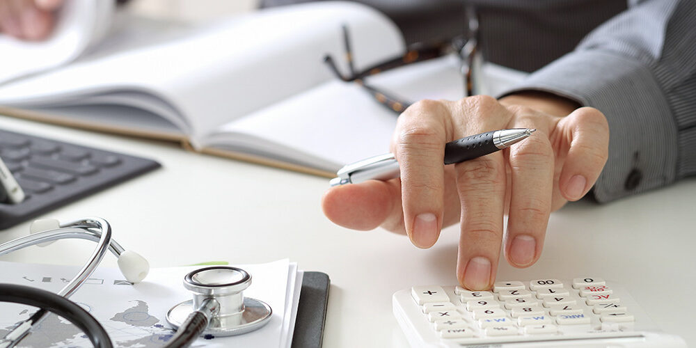 a person writing and using a calculator